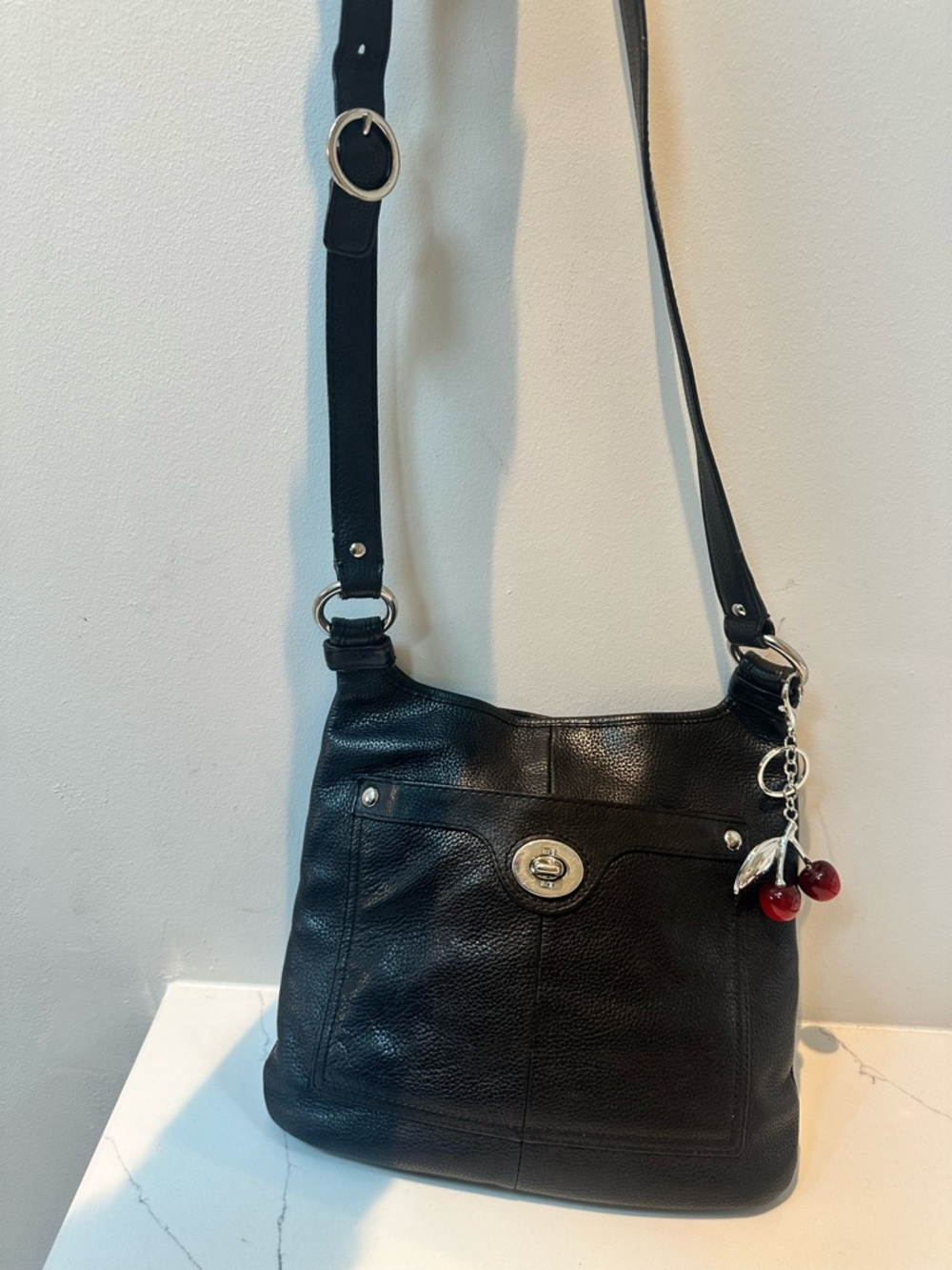 Coach crossbody with Turnlock on pocket with no-brand cherry charm